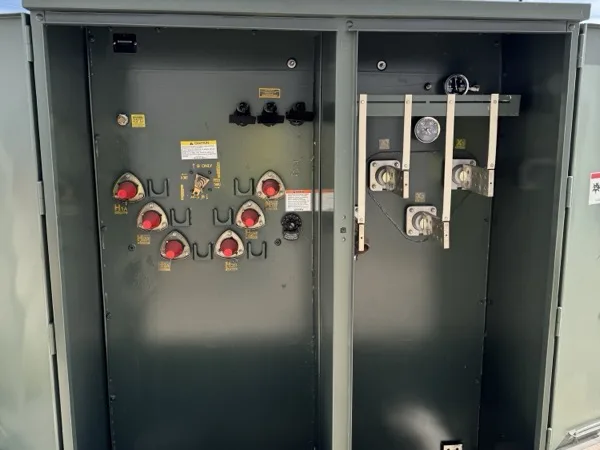 Open pad mounted transformer showing the primary bushings and secondary compartment before cabling