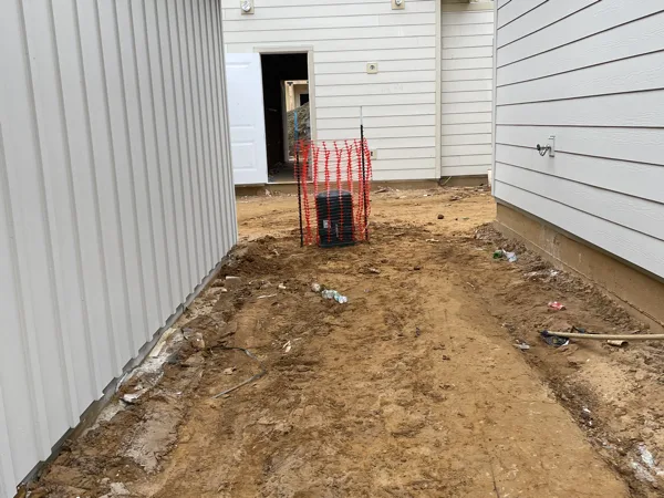 Graded trench line between two finished buildings