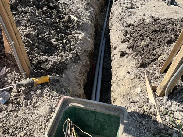 Underground pull box set in a trench with conduits entering it
