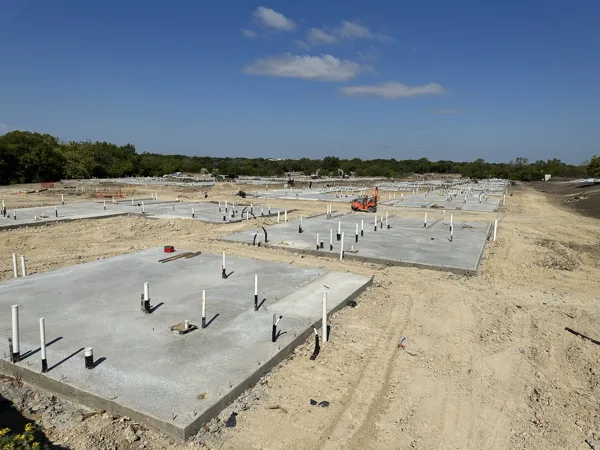 Rows of building slabs with electrical stub ups across a graded site