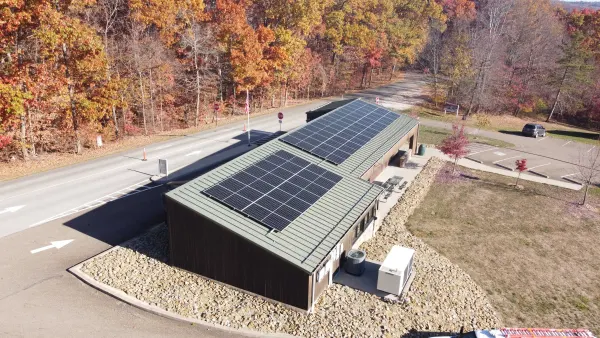 22.9 kW solar array on the standing-seam roof of the Seneca Lake park office in Senecaville, Ohio, surrounded by fall foliage