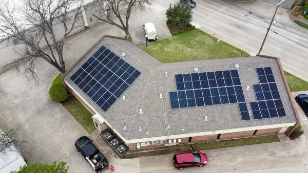 Aerial view of a 32.6 kW rooftop solar array on a brick office building in Fort Worth, Texas