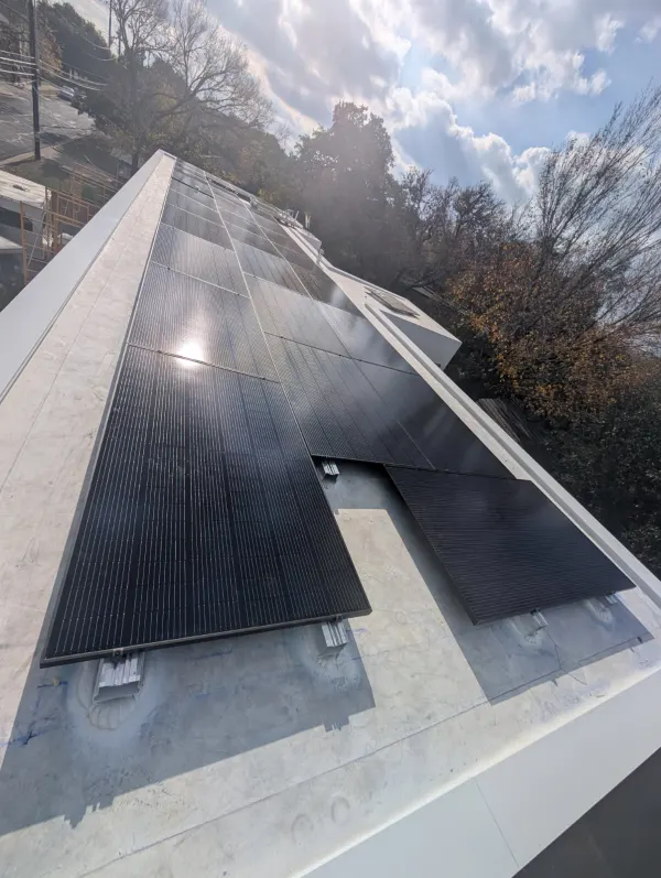 14 kW all-black solar modules on the white flat roof of a home in Austin, Texas